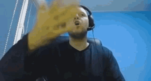 a man wearing headphones and a black shirt is sitting in a chair .