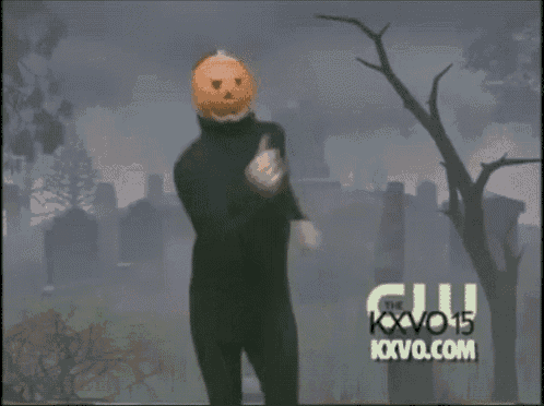 a man with a pumpkin on his head is dancing in a cemetery sponsored by kxvo.com