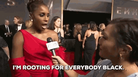 a woman in a red dress is being interviewed on the red carpet and says i 'm rooting