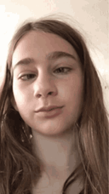 a close up of a young girl 's face with long hair .