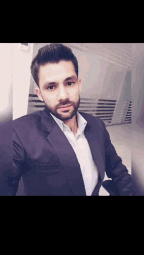 a man with a beard wearing a suit and a white shirt