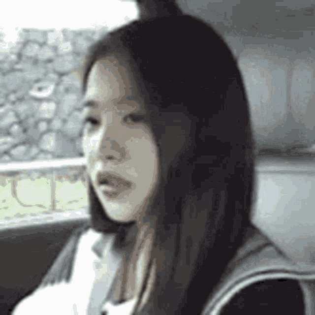 a woman with long hair is sitting in the back seat of a car .