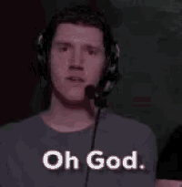 a man wearing headphones is covering his face with his hand while laughing .