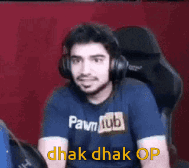a man wearing headphones and a pawn hub shirt says ' dhak dhak op '