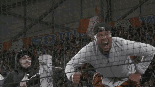 a man behind a fence with a sign that says ' olympus ' on it