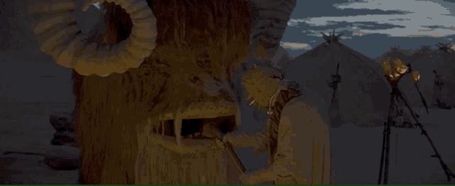 a statue of a monster with horns is standing in front of tents