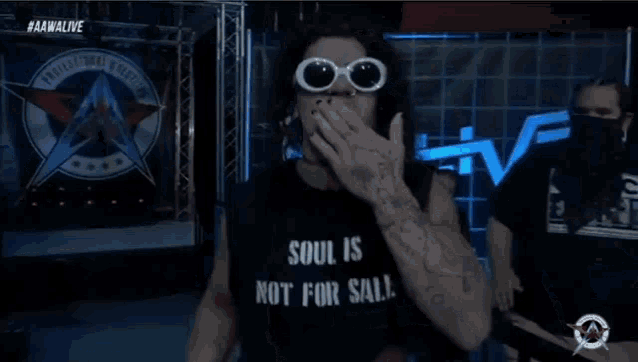 a man wearing sunglasses and a shirt that says soul is not for sale covers his mouth