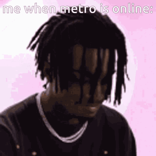 a man with dreadlocks is wearing a necklace and a black shirt .