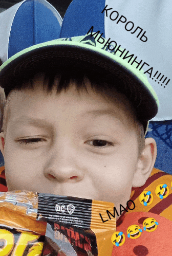 a young boy wearing a hat and eating a batman snack