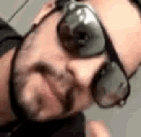 a man with a beard is wearing sunglasses and making a funny face