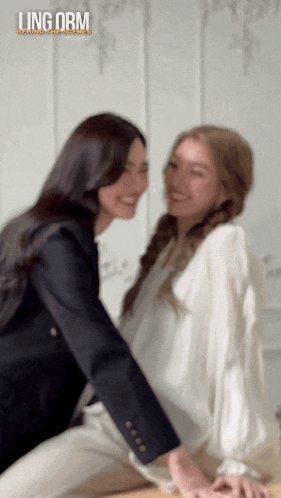 a blurry photo of two women with the words ling orm on the bottom left