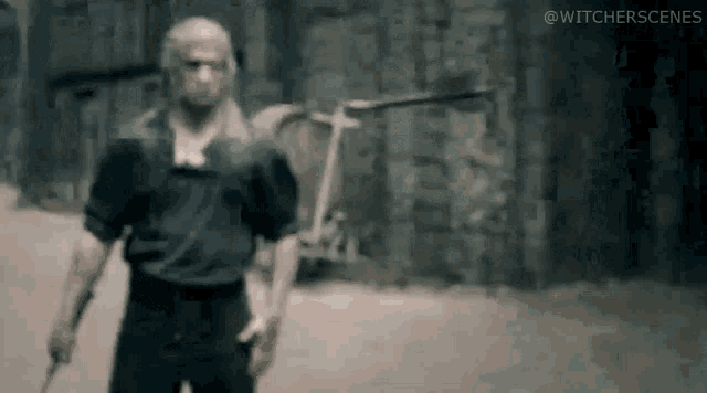 a man is standing in front of a brick wall holding a knife .