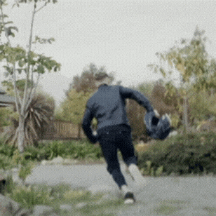 a man in a blue jacket is running down a path