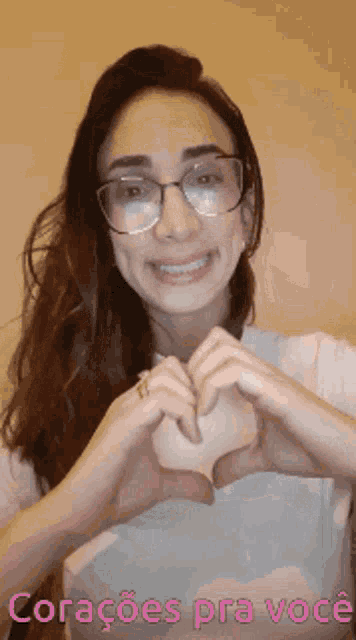 a woman wearing glasses is making a heart shape with her hands and the words coracoes pra voce below her