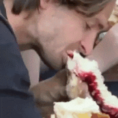a man is eating a piece of cake with raspberry jam on it .