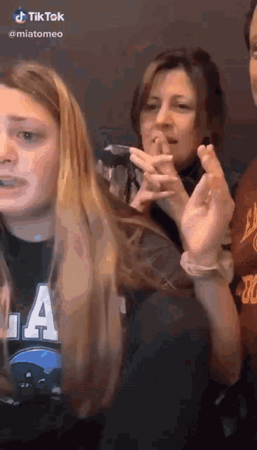 a group of women are standing next to each other and one of them is wearing a shirt that says la on it .