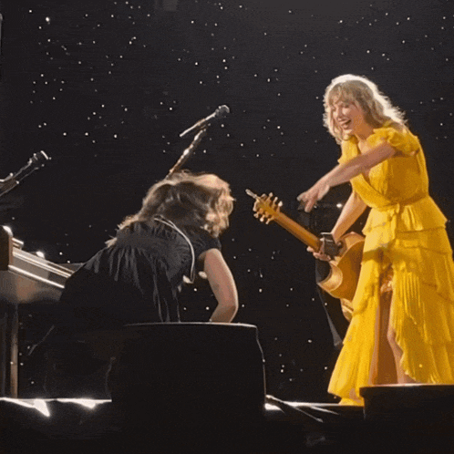 a woman in a yellow dress is hugging another woman