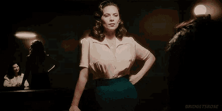 a woman in a white shirt is smiling and looking to the side .
