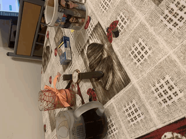 a table cloth with ladybugs on it and a watch on it