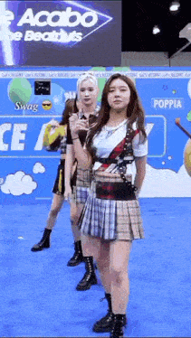 a group of girls are standing on a blue carpet in front of a sign that says swag .