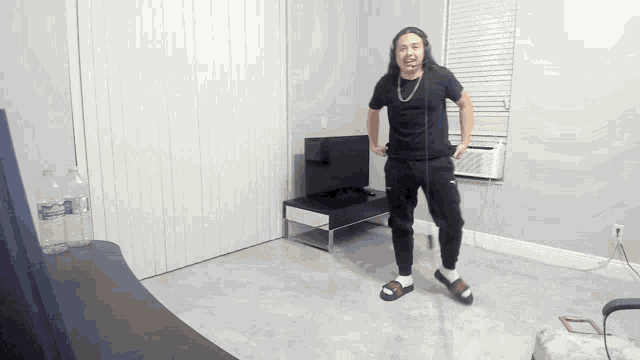 a man is jumping a rope in a room with a bottle of aquafina water in the background