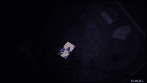 a cartoon character is sitting in a dark room with a lot of cards on the floor .