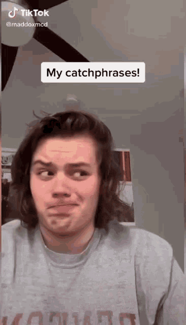 a man with long hair is making a funny face and says " my catchphrases " in the corner