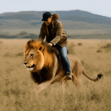a person riding on the back of a lion in a field