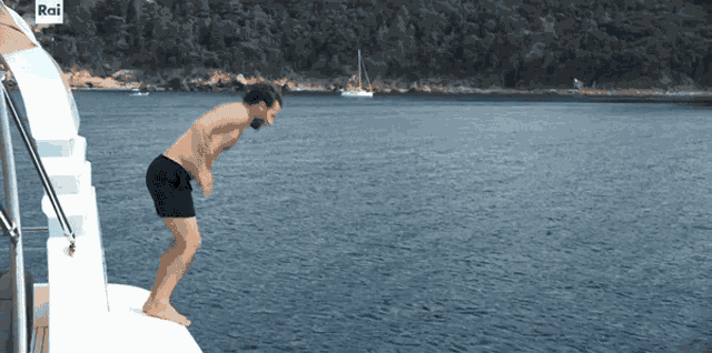 a man is jumping into the water from a boat with rai on the side