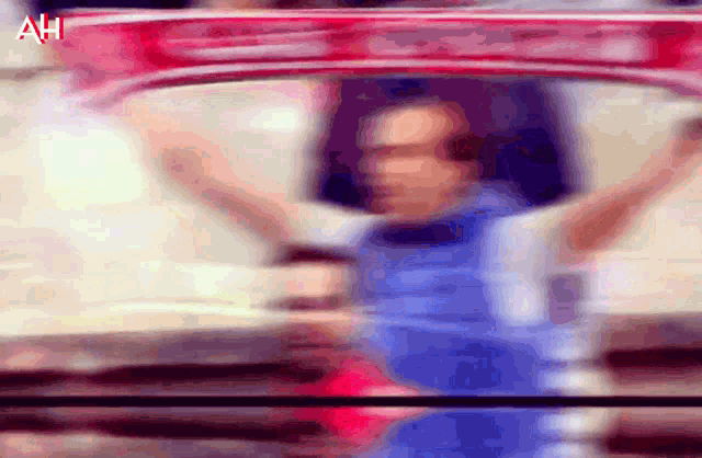 a blurry picture of a person holding a red scarf with the letters ah on the bottom right