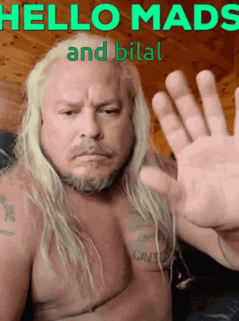 a shirtless man with long blonde hair says hello mads
