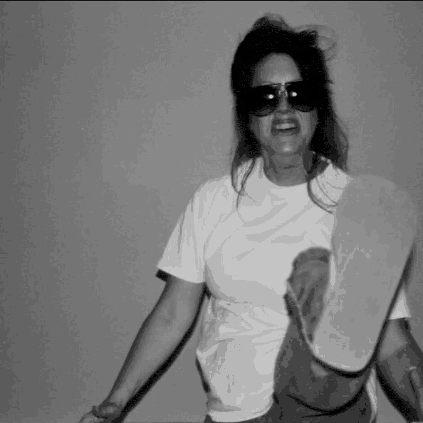 a black and white photo of a woman wearing sunglasses and a white t-shirt