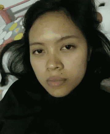 a woman is laying on a bed with her eyes closed and her hair blowing in the wind