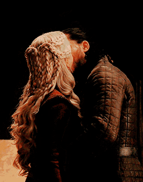 a man and a woman are kissing in the dark