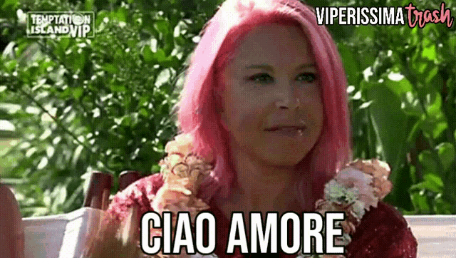 a woman with pink hair says ciao amore in a video