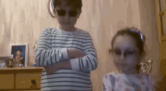 a boy and a girl are standing next to each other in a room .