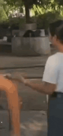 two people are standing next to each other on a sidewalk .