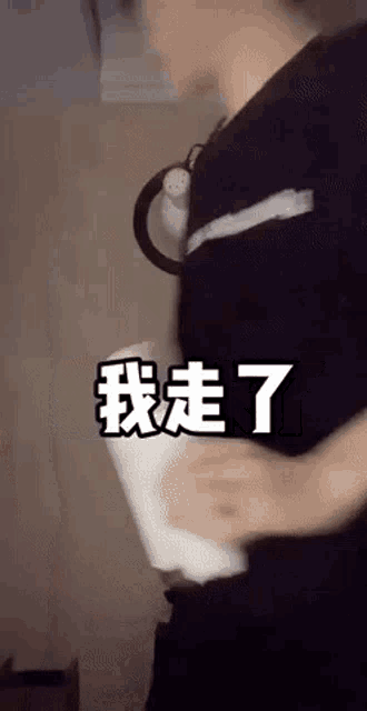 a man in a black shirt is holding a piece of paper with chinese characters on it .