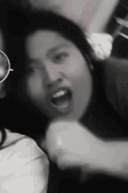 a woman wearing sunglasses is making a funny face in a black and white photo