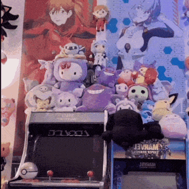 a bunch of stuffed animals are sitting on top of an arcade machine that says tokyo on it