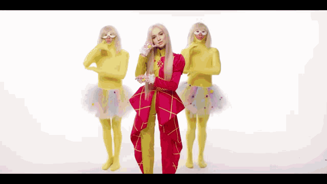 a woman in a red and yellow outfit is standing next to two women in yellow tights
