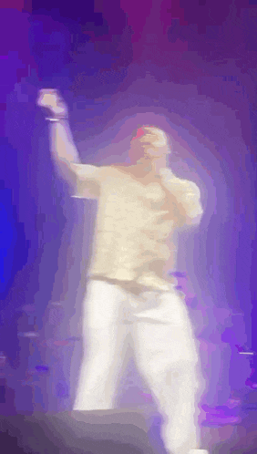 a blurry picture of a man singing into a microphone on a stage