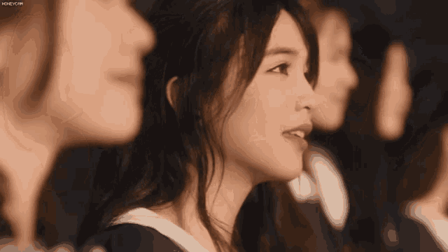 a group of young women are sitting in a row and one of them is wearing a graduation cap and gown