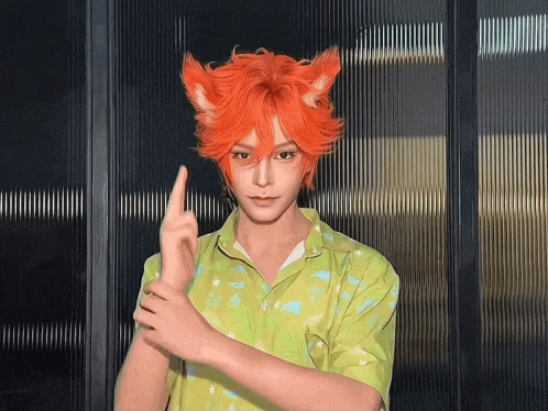 a man with orange hair and ears is wearing a green shirt and making a peace sign