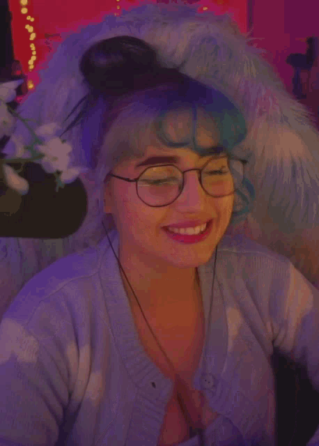a girl with blue hair and glasses is smiling and covering her face with her hands