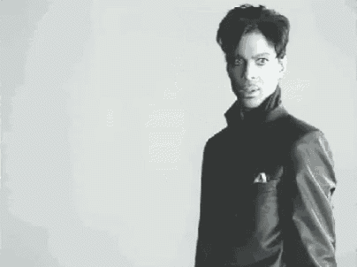 a black and white photo of a man wearing a suit and a turtleneck .