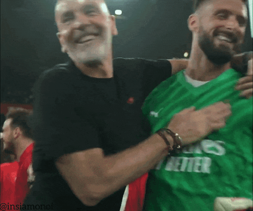 a man wearing a green emirates shirt smiles