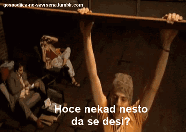 a man is holding a large piece of wood over his head with the words hoce nekad nesto da se desi on the bottom