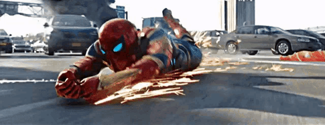 a man in a spiderman costume is laying on the street