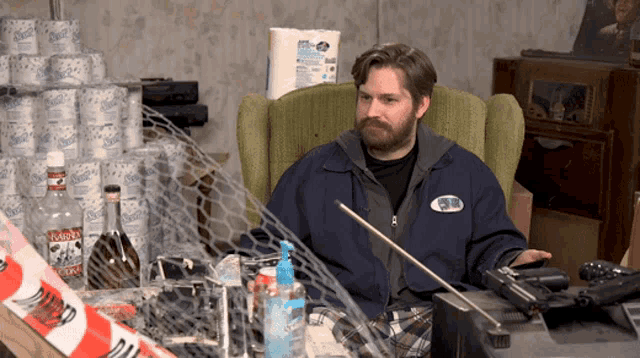 a man is sitting in a chair in front of a stack of kleenex paper towels